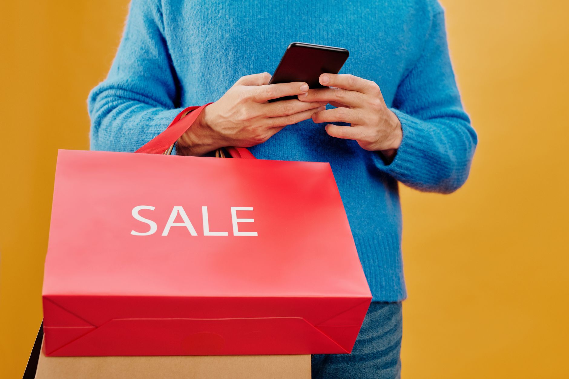 Shopper reading a sale email on a phone, illustrating the H&M Washington CEMA class action